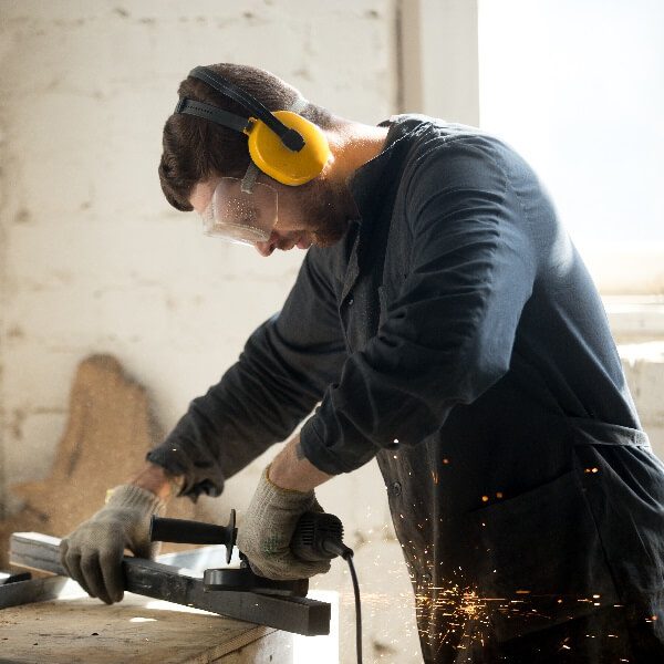 Industrial worker operating a machine with hearing protection