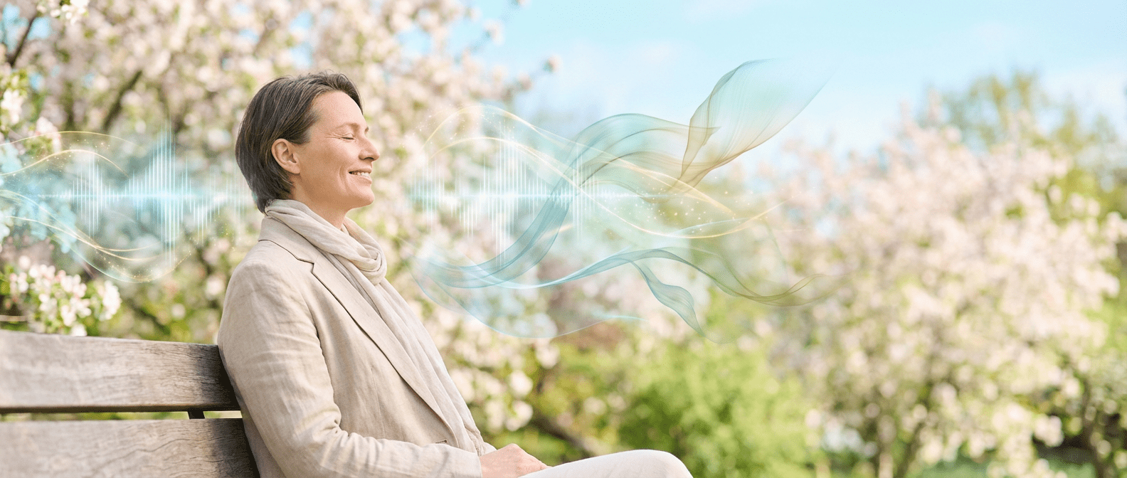 Week 19 Calm adult seated outdoors in a spring setting with soft abstract sound-wave patterns flowing through the air, symbolizing listening, communication, and hearing awareness.